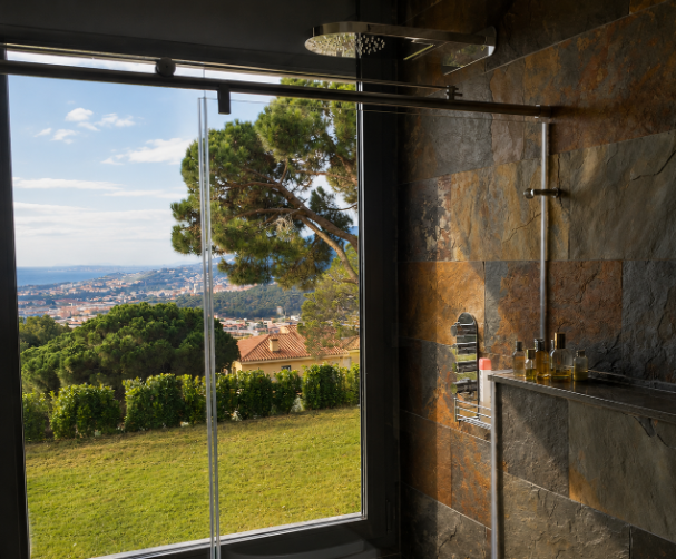 Baño con ducha y vistas panorámicas al mar y al entorno natural
