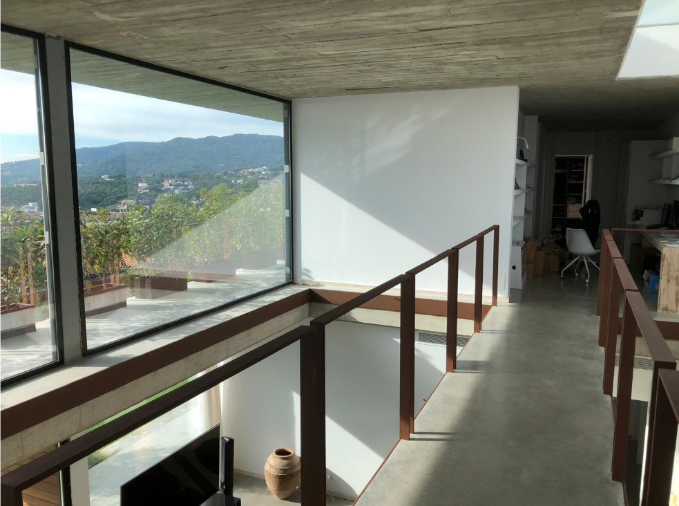 Paso en planta superior con ventanal de esquina y vistas al valle