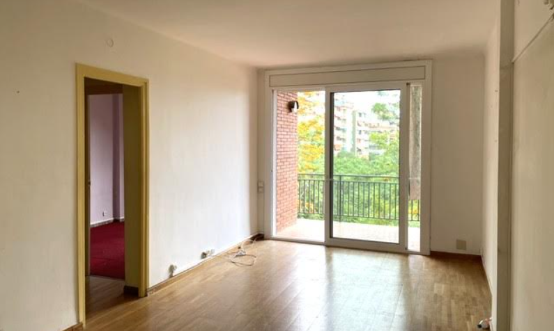 Salón antes de la reforma, vacío con suelo de parquet y acceso a terraza