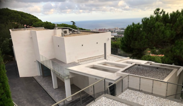 Vista aérea de la vivienda con terrazas, jardín y vistas al mar