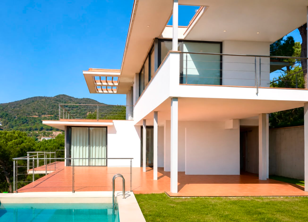 Vista exterior de la vivienda con piscina, terraza y volúmenes blancos